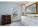 Bright bathroom features a window with a view, vanity, beautiful mirror, and storage at 2814 La Mancha Ct, Punta Gorda, FL 33950