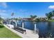 Waterfront dock featuring boat lifts, an American flag, seating, and neighborhood views for outdoor enjoyment at 2814 La Mancha Ct, Punta Gorda, FL 33950