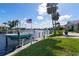 Waterfront dock featuring boat lifts, an American flag, and manicured lawn with palm trees for relaxing outdoors at 2814 La Mancha Ct, Punta Gorda, FL 33950