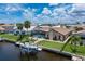 Rear exterior of waterfront home with private dock, boat lift, and manicured lawn at 2814 La Mancha Ct, Punta Gorda, FL 33950
