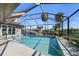 Screened-in swimming pool offers clear blue water and a view of the waterfront and palm trees for relaxation and fun at 2814 La Mancha Ct, Punta Gorda, FL 33950