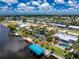 Beautiful aerial view of waterfront home with pool, lush landscaping, boat dock and stunning waterfront views at 330 Weber Ter, Port Charlotte, FL 33952