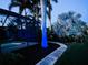 Beautiful backyard with in-ground pool, enclosed lanai, lush landscaping, and ambient up-lighting at 330 Weber Ter, Port Charlotte, FL 33952
