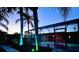 Beautiful backyard with in-ground pool, enclosed lanai, lush landscaping, and ambient up-lighting at 330 Weber Ter, Port Charlotte, FL 33952