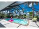 Covered pool, with a flamingo float, lounge chair, and palm trees at 330 Weber Ter, Port Charlotte, FL 33952