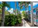 Lush landscaping frames a serene pathway, offering privacy and leading to the pool and home at 330 Weber Ter, Port Charlotte, FL 33952