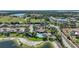 Aerial view of a community clubhouse and pool surrounded by lush landscaping and mature trees at 3631 Pebble Ter, Punta Gorda, FL 33980