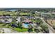 An aerial view of a community pool with a red tile roofed cabana and well maintained landscaping and green lawns at 3631 Pebble Ter, Punta Gorda, FL 33980