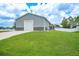 Exterior of the property showcasing a lush lawn, shed, and ample parking space at 369 Hyacinth St, Port Charlotte, FL 33954
