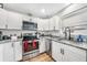 Well-lit kitchen with white cabinets, granite counters, stainless steel appliances, and hardwood flooring at 369 Hyacinth St, Port Charlotte, FL 33954