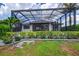 Lush backyard featuring a screened-in pool, covered patio, and well-maintained landscaping at 3800 Carupano Ct, Punta Gorda, FL 33950