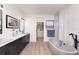 Bright bathroom featuring a double vanity, freestanding tub, and a view into a walk-in closet for extra storage at 3800 Carupano Ct, Punta Gorda, FL 33950