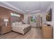 Comfortable bedroom with a tray ceiling, wood-look tile flooring, and natural light at 3800 Carupano Ct, Punta Gorda, FL 33950