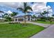 A modern home with a well-kept lawn, palm trees, manicured landscaping, and a symmetrical design at 3800 Carupano Ct, Punta Gorda, FL 33950