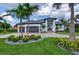 A modern home exterior with well-manicured landscaping, palm trees, and a symmetrical facade at 3800 Carupano Ct, Punta Gorda, FL 33950