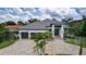 Expansive aerial view of luxury home with manicured lawn, lush landscaping, and circular driveway at 3800 Carupano Ct, Punta Gorda, FL 33950