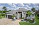 Striking home showcasing lush landscaping, a three-car garage, and an inviting entrance at 3800 Carupano Ct, Punta Gorda, FL 33950
