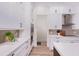 Elegant kitchen featuring white cabinets, stainless steel appliances, and wood-look tile flooring at 3800 Carupano Ct, Punta Gorda, FL 33950