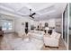 Open-concept living room featuring coffered ceilings, wood-look tile, neutral furniture, and an adjacent kitchen with an island at 3800 Carupano Ct, Punta Gorda, FL 33950