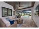 Inviting outdoor living area with comfortable seating, ceiling fan, and a view of the sparkling pool at 3800 Carupano Ct, Punta Gorda, FL 33950
