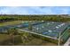 Aerial view of several outdoor pickleball courts in a green landscape with palm trees at 3800 Carupano Ct, Punta Gorda, FL 33950