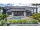 Backyard featuring a screened-in pool area with covered patio and lush landscaping at 3800 Carupano Ct, Punta Gorda, FL 33950