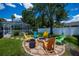 Outdoor firepit seating area with colorful Adirondack chairs and lush green landscaping at 3824 Dominic St, North Port, FL 34288