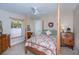 Cozy bedroom with a four-poster bed, ceiling fan, window with blinds, and a wooden dresser at 3824 Dominic St, North Port, FL 34288