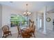 Bright dining room with hardwood table and chairs, a harp, and a chandelier at 3824 Dominic St, North Port, FL 34288