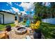 View of outdoor fire pit and seating area near a home with lush green landscaping at 3824 Dominic St, North Port, FL 34288