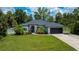 Charming single-story home featuring a well-manicured lawn and lush landscaping at 3824 Dominic St, North Port, FL 34288