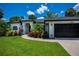 Charming home with lush landscaping, a manicured lawn, and a welcoming entrance at 3824 Dominic St, North Port, FL 34288
