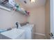 Well-lit laundry room with sink, washer, dryer, and shelving at 3824 Dominic St, North Port, FL 34288