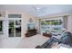 Bright living room featuring a ceiling fan, television, and a view of the pool area at 3824 Dominic St, North Port, FL 34288