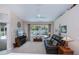 Spacious living room area features a comfortable sofa, large windows, and view to a screened-in pool at 3824 Dominic St, North Port, FL 34288