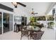 Enclosed patio area with dining table and chairs, ceiling fans, and television at 3824 Dominic St, North Port, FL 34288