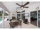 Enclosed patio area with dining table and chairs, ceiling fans, and television at 3824 Dominic St, North Port, FL 34288