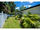 Landscaped yard with fence, tropical plants and access to screened patio at 3824 Dominic St, North Port, FL 34288