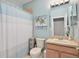 Bathroom with light blue walls, shower with curtain, vanity, and palm tree art at 4180 Lenox Blvd, Venice, FL 34293