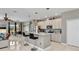 Bright, open kitchen with white cabinets, stainless steel appliances, and a kitchen island with seating at 4180 Lenox Blvd, Venice, FL 34293