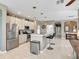 Spacious kitchen featuring a stainless steel refrigerator, white cabinets and an island with bar stool seating at 4180 Lenox Blvd, Venice, FL 34293