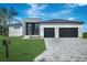 Stunning modern home with a two-car garage, clean lines, and beautiful stone driveway at 44 Sunflower Dr, Placida, FL 33946