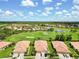 Birds eye view of homes next to a golf course and ponds in a sunny neighborhood at 4567 Whispering Oaks Dr, North Port, FL 34287
