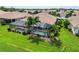 Aerial view of a screened in pool, palm trees, and manicured lawn at 4567 Whispering Oaks Dr, North Port, FL 34287