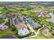 Expansive aerial view of community amenities including a golf course, pool, tennis courts, and clubhouse at 4567 Whispering Oaks Dr, North Port, FL 34287