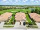 Aerial view of a home with a clay tile roof, landscaping, and golf course backdrop at 4567 Whispering Oaks Dr, North Port, FL 34287