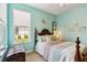 This bedroom's walls are painted light blue, with a four-poster bed and bright window views at 4567 Whispering Oaks Dr, North Port, FL 34287