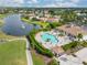 Aerial view of community pool with lake view, lush landscaping, and nearby community amenities at 4567 Whispering Oaks Dr, North Port, FL 34287