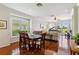 Dining room and open-concept living room with hardwood floors and views of the backyard and golf course at 4567 Whispering Oaks Dr, North Port, FL 34287