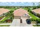 Exterior of a home featuring lush landscaping, a clay tile roof, and a two-car garage at 4567 Whispering Oaks Dr, North Port, FL 34287